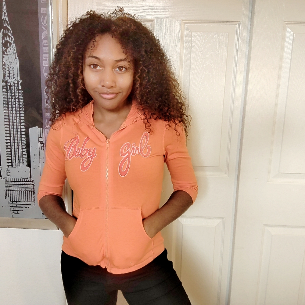 A orange jacket with baby girl on it